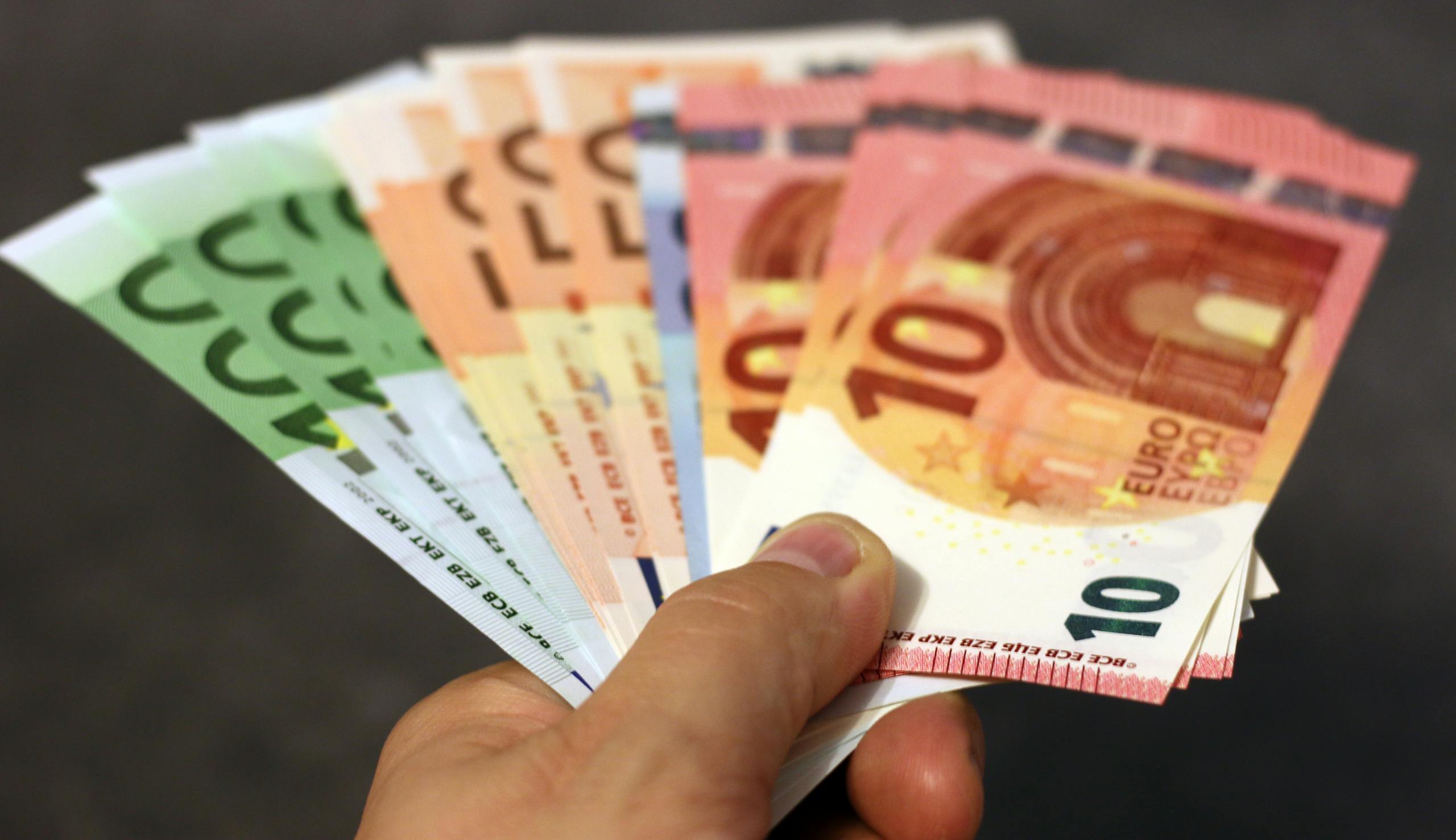 Ein Fächer Euro-Scheine, der in einer Hand gehalten wird.