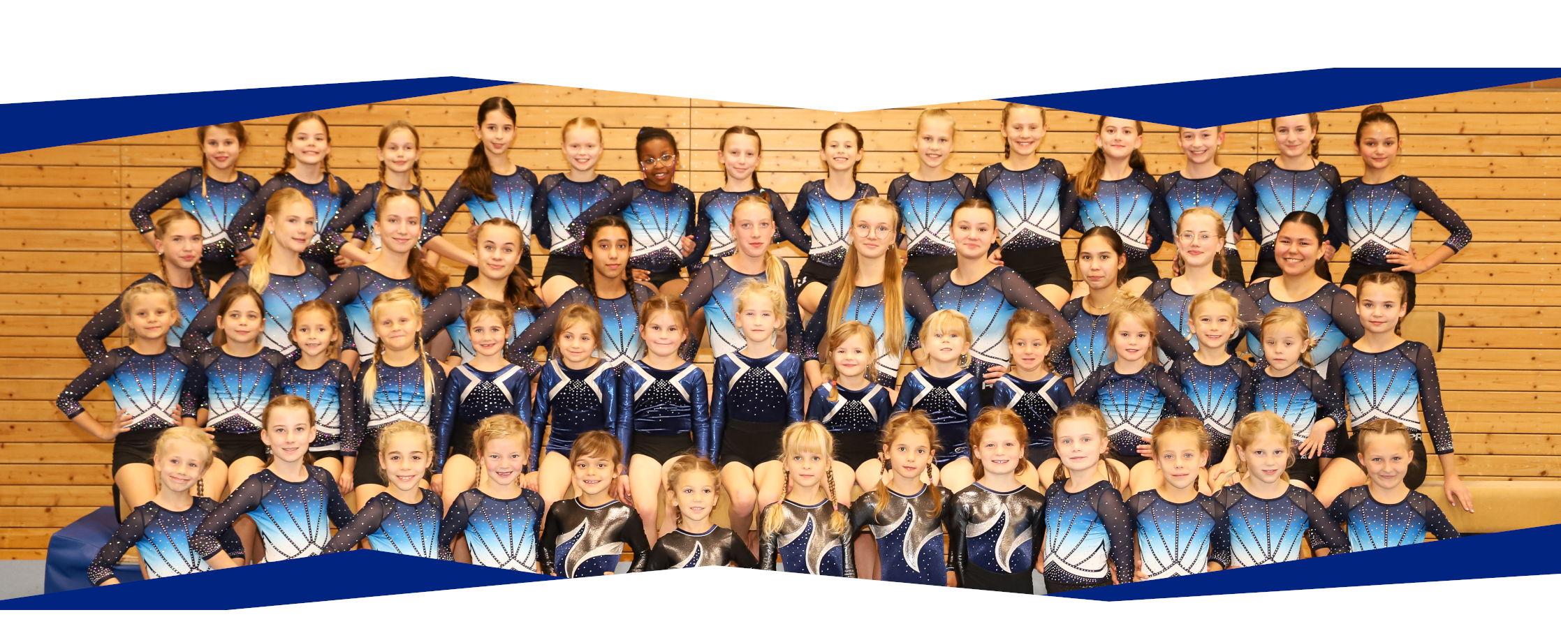 Gruppenbild mit fast allen unseren  Wettkampfturnerinnen verschiedenster Altersklassen auf einem Bild. Sie tragen unsere Wettkampfanzüge.