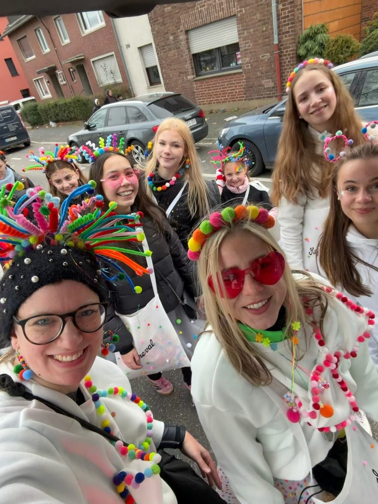 Gruppenbild: 9 Teilnehmende mit bunten Konfetti-Kostümen.